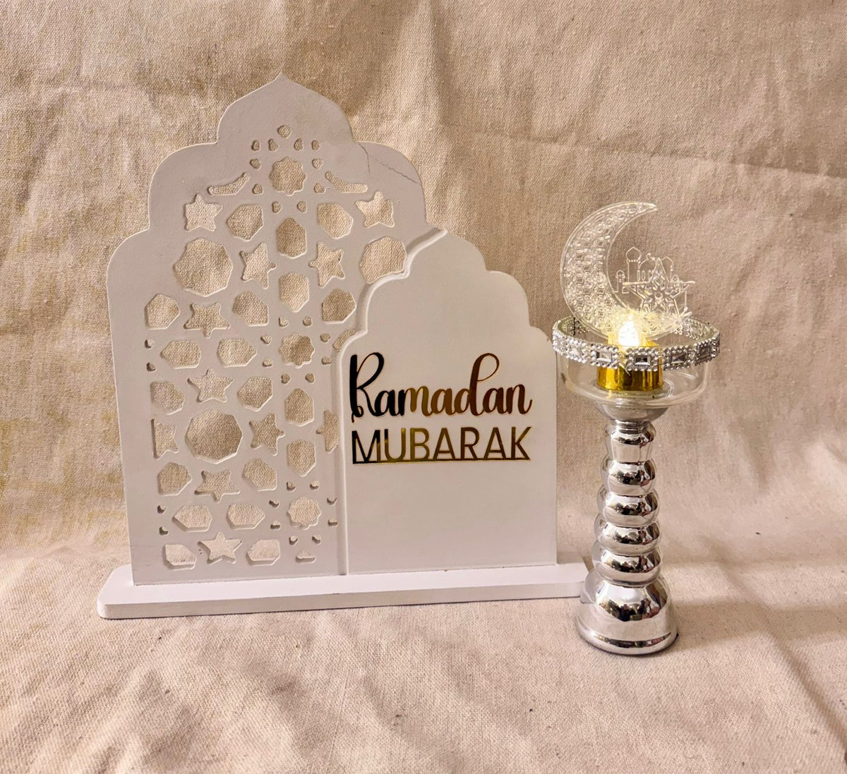white ramadan sign with silver candle holder